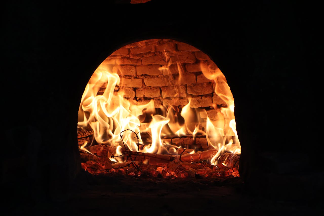Captivating image of a roaring fire inside a traditional wood-fired oven, exuding warmth and rustic charm.